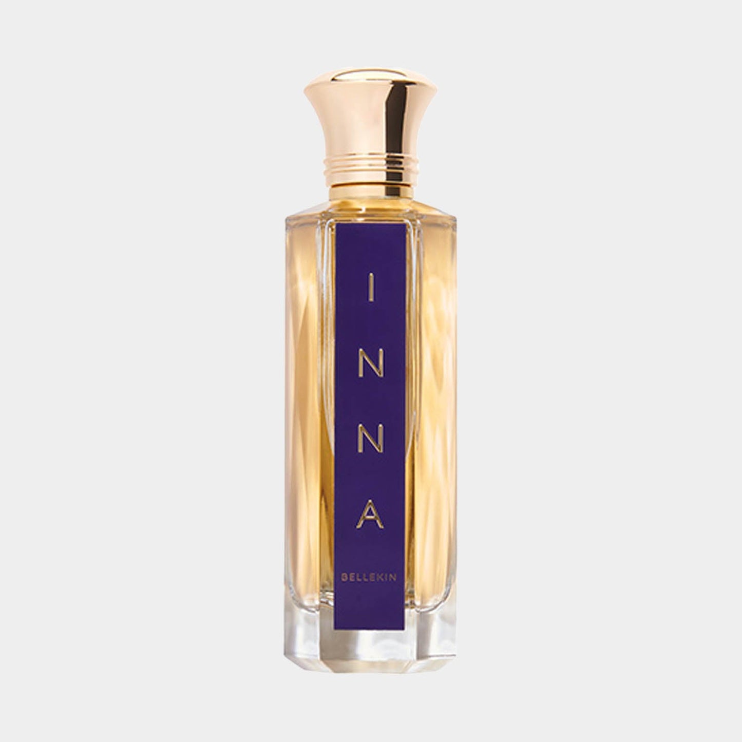 A sleek, elegant perfume bottle labeled 'Inna' by Bellekin, featuring a gold cap and a striking blue label. The fragrance inside has a warm golden hue, suggesting a luxurious scent.