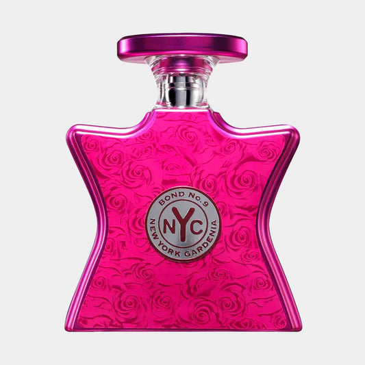 A full bottle of Bond No. 9 New York Gardenia, featuring a vibrant pink star-shaped design adorned with embossed roses and a silver logo at the center. The elegant bottle captures the essence of floral femininity.