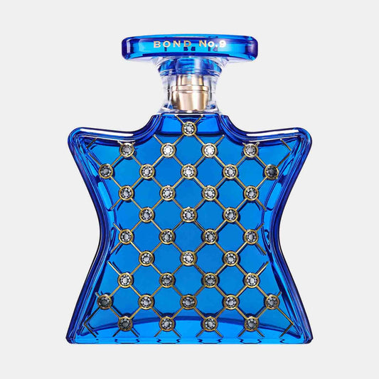 A blue star-shaped bottle of Bond No.9 NoMad Sample, adorned with a decorative pattern of silver studs, showcasing an elegant and luxurious design.