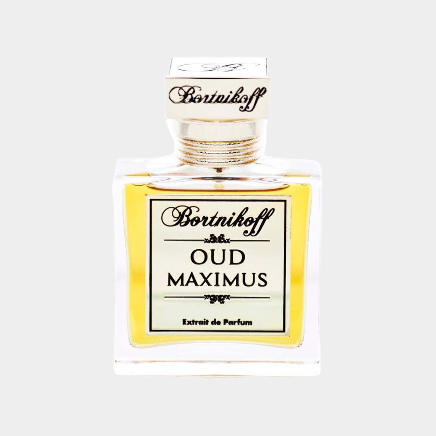 A clear glass bottle of Bortnikoff Oud Maximus Sample, featuring a gold and cream label and a stylish cap, showcasing a rich, golden liquid inside. This extrait de parfum is designed for fragrance enthusiasts seeking luxurious oud notes.