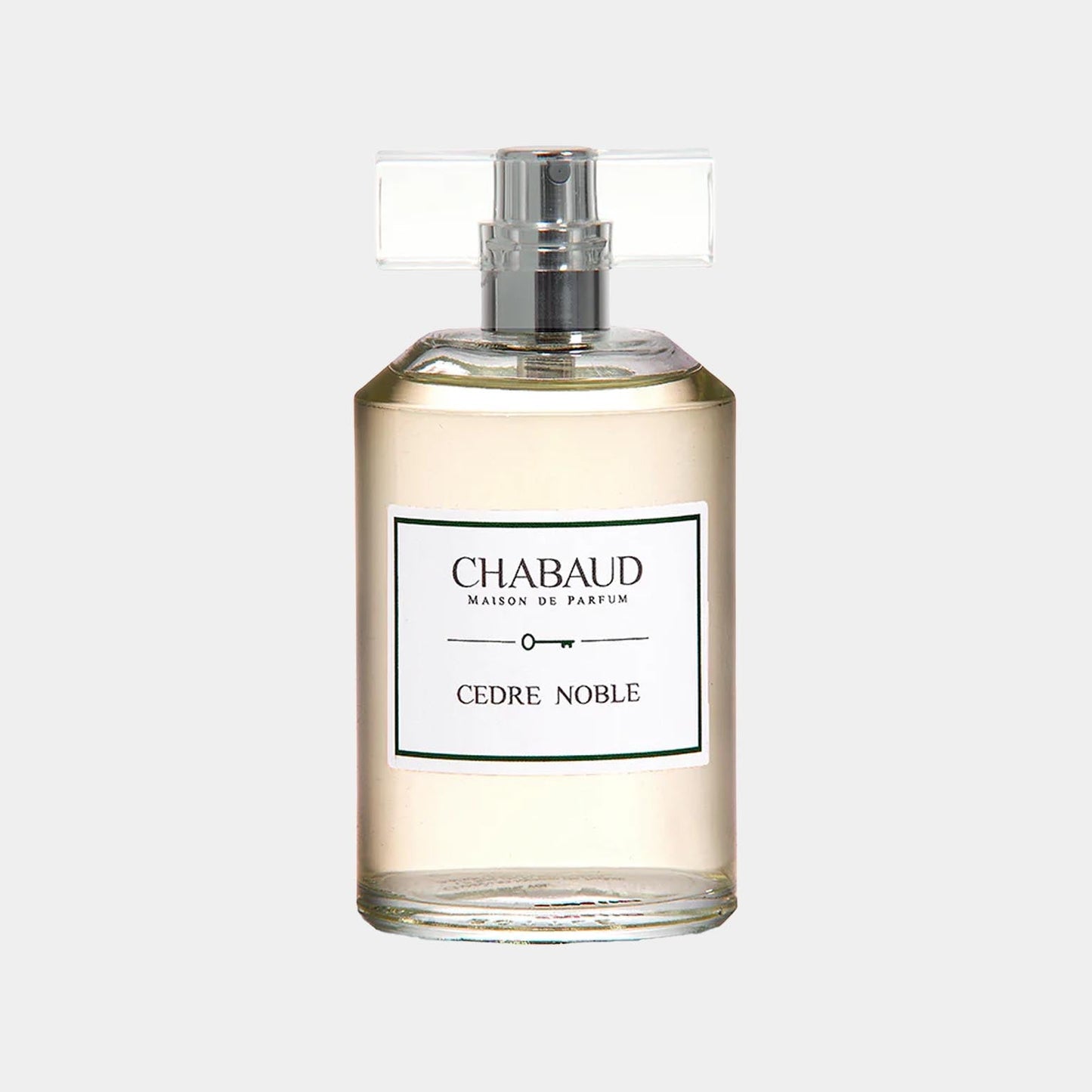 A clear perfume bottle labeled Chabaud Maison de Parfum Cedre Noble, featuring a streamlined design and a simple silver cap, showcasing a light, amber-colored liquid inside.