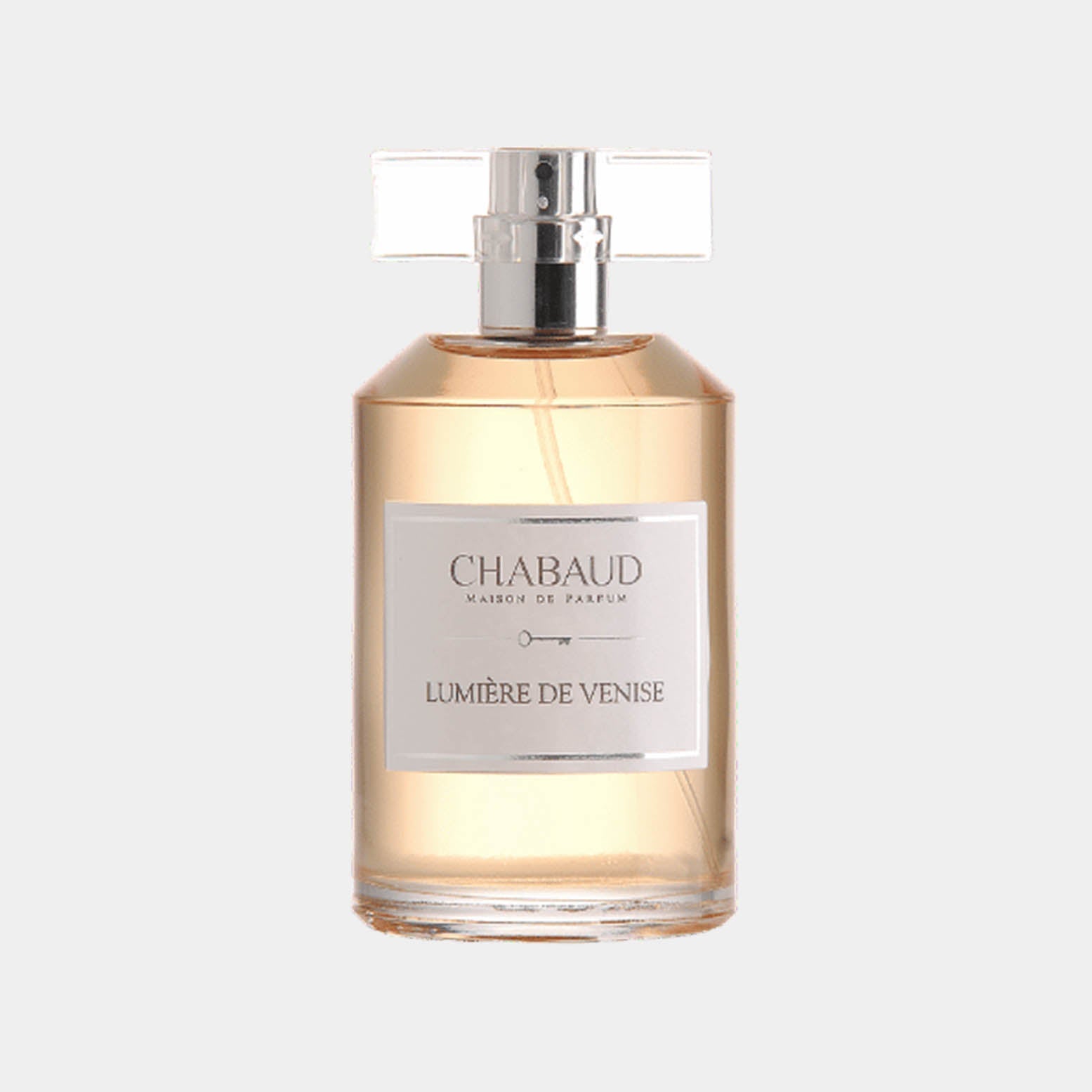 A stylish glass fragrance bottle labeled Chabaud Maison de Parfum Lumière de Venise, showcasing a delicate amber liquid inside. The bottle features a sleek design with a clear cap, reflecting elegance.