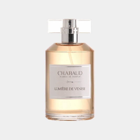 A stylish glass fragrance bottle labeled Chabaud Maison de Parfum Lumière de Venise, showcasing a delicate amber liquid inside. The bottle features a sleek design with a clear cap, reflecting elegance.