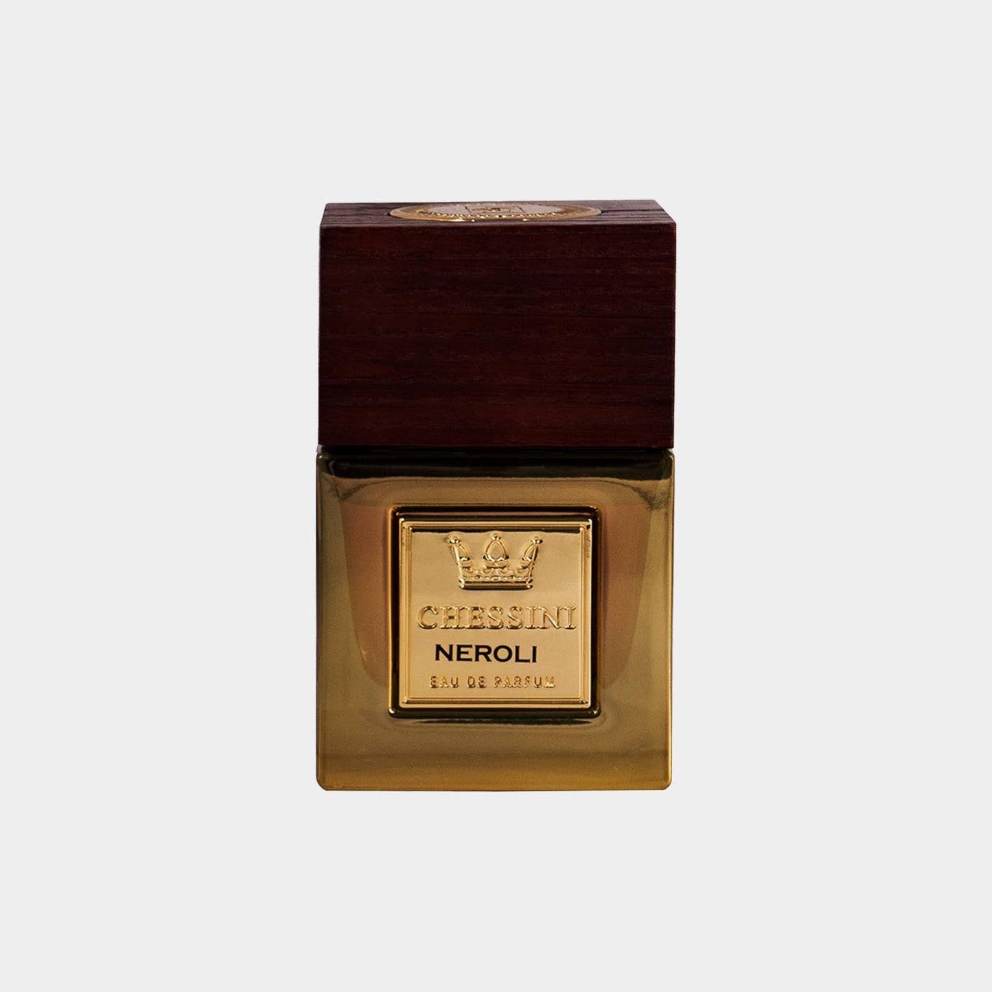 A full bottle of Chessini Neroli perfume, featuring a sleek glass design with a wooden cap and a gold label embossed with the brand's logo. The warm amber liquid inside adds an elegant touch.
