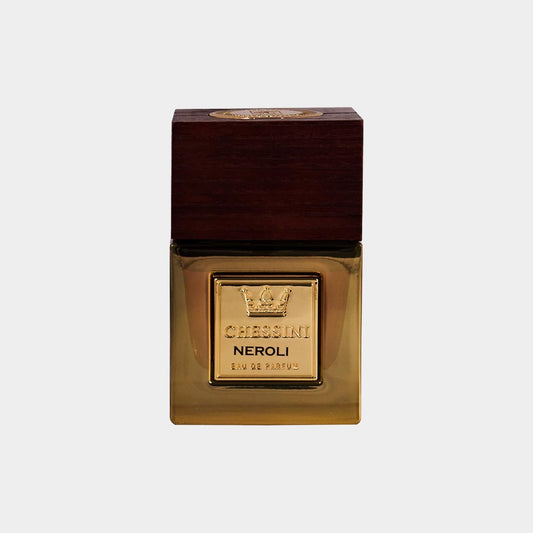 A full bottle of Chessini Neroli perfume, featuring a sleek glass design with a wooden cap and a gold label embossed with the brand's logo. The warm amber liquid inside adds an elegant touch.