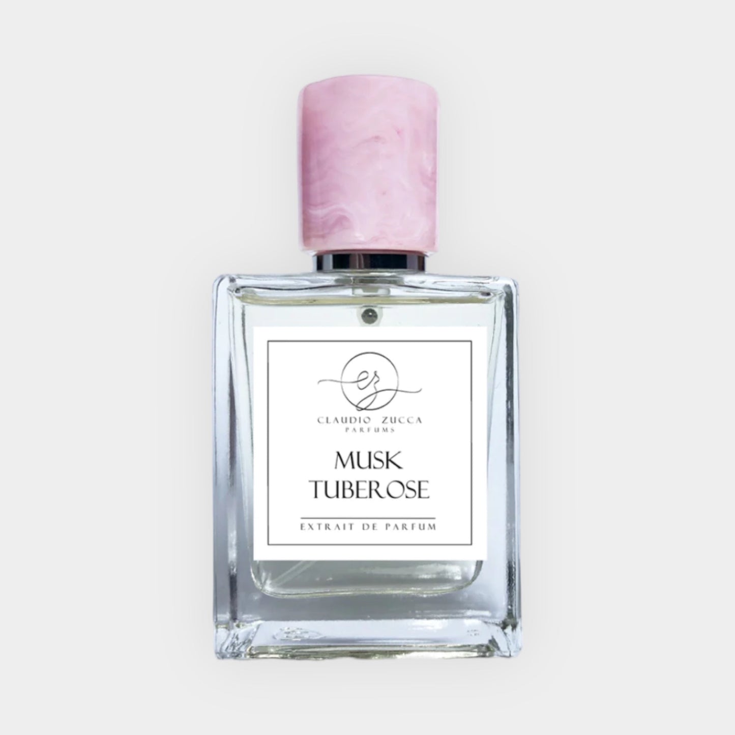 A clear glass bottle of Claudio Zucca Musk Tuberose Sample, featuring a pink marbled cap and a minimalist label that reads Musk Tuberose Extrait de Parfum.