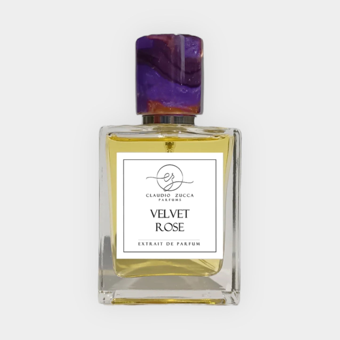 A full bottle of Claudio Zucca Velvet Rose, featuring a clear square glass design with a vibrant, multicolored cap. The label prominently displays the fragrance name and Extrait de Parfum beneath it.