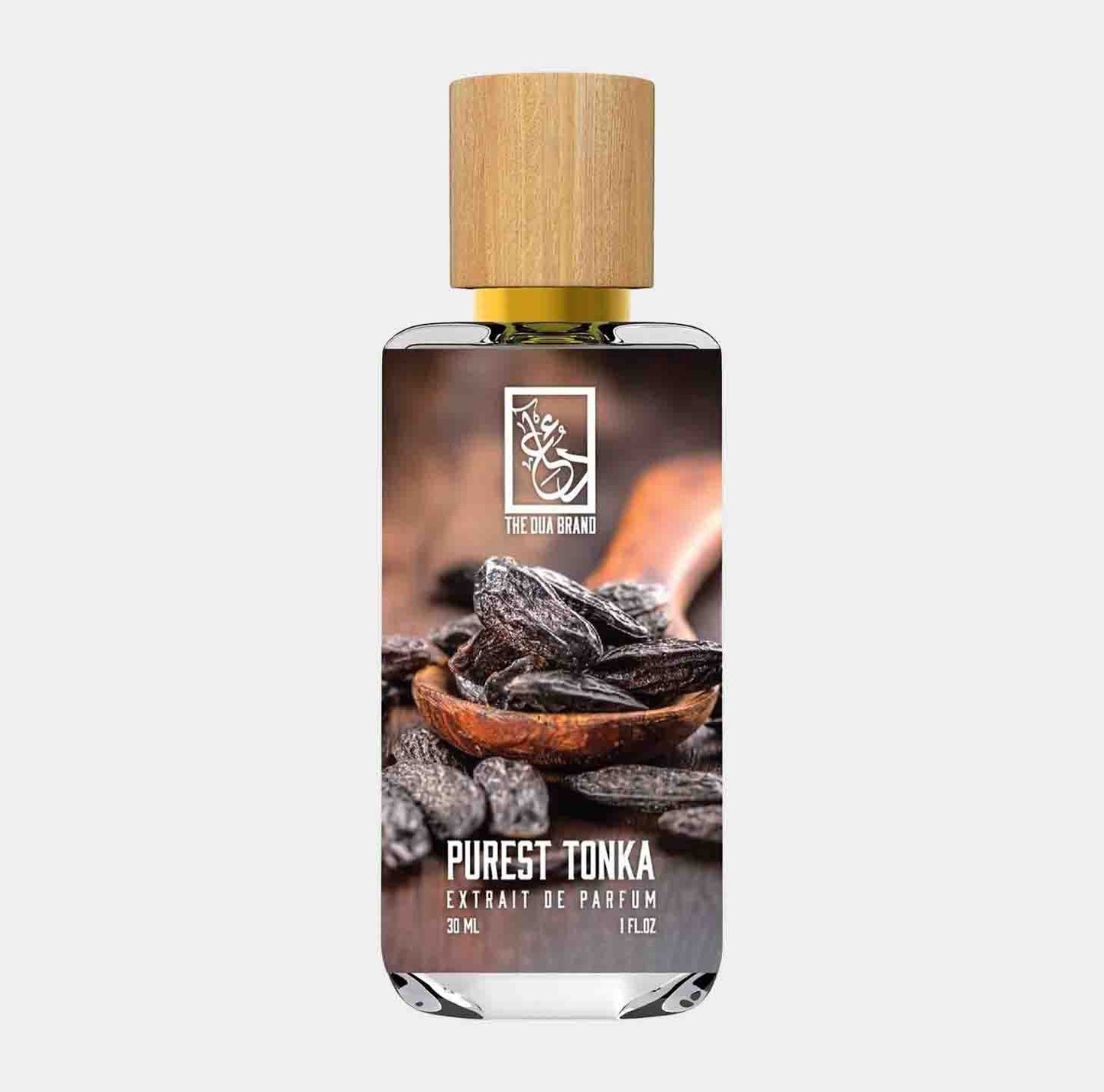 A bottle of Dua Purest Tonka, an extrait de parfum, featuring a wooden cap and a label adorned with cocoa beans and tonka pods. The 30 mL bottle is elegantly designed, showcasing a rich and inviting fragrance.