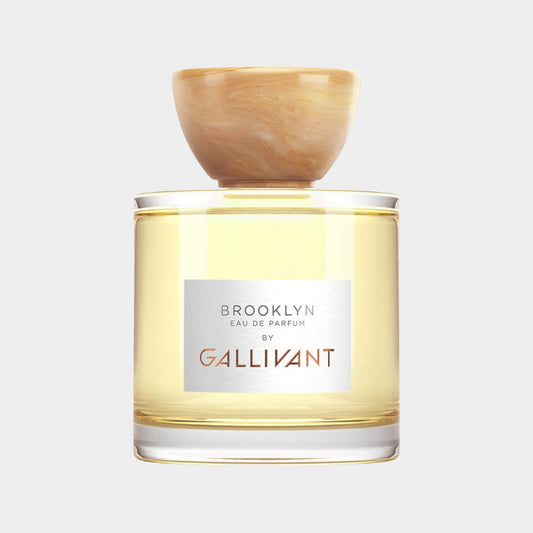 Gallivant Brooklyn Full bottle featuring an elegant clear glass design with a light yellow fragrance and a round, natural wood cap.