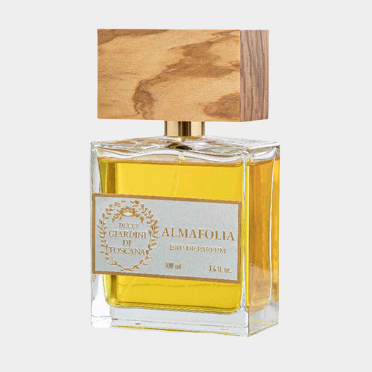 A glass perfume bottle of Giardini di Toscana Almafolia Sample, featuring a wooden cap and filled with a golden liquid, showcasing an elegant design perfect for fragrance enthusiasts.