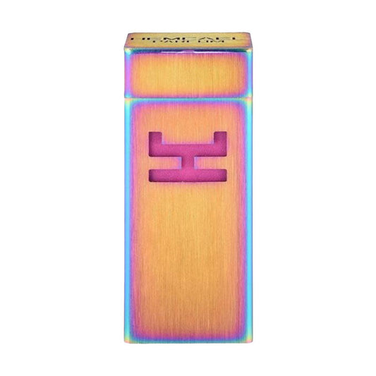 A full bottle of Hemcael Amantes, featuring a vibrant, iridescent design with a bold pink logo against a gold background. The unique packaging showcases a modern, artistic shape.