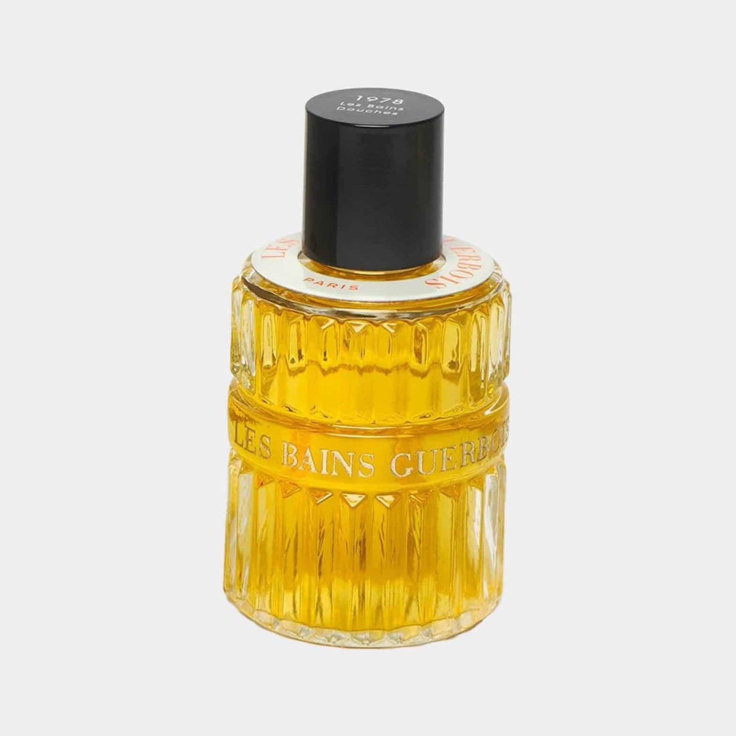Les Bains Guerbois Douches 1978 full bottle featuring a textured glass design and a sleek black cap, filled with a golden liquid.
