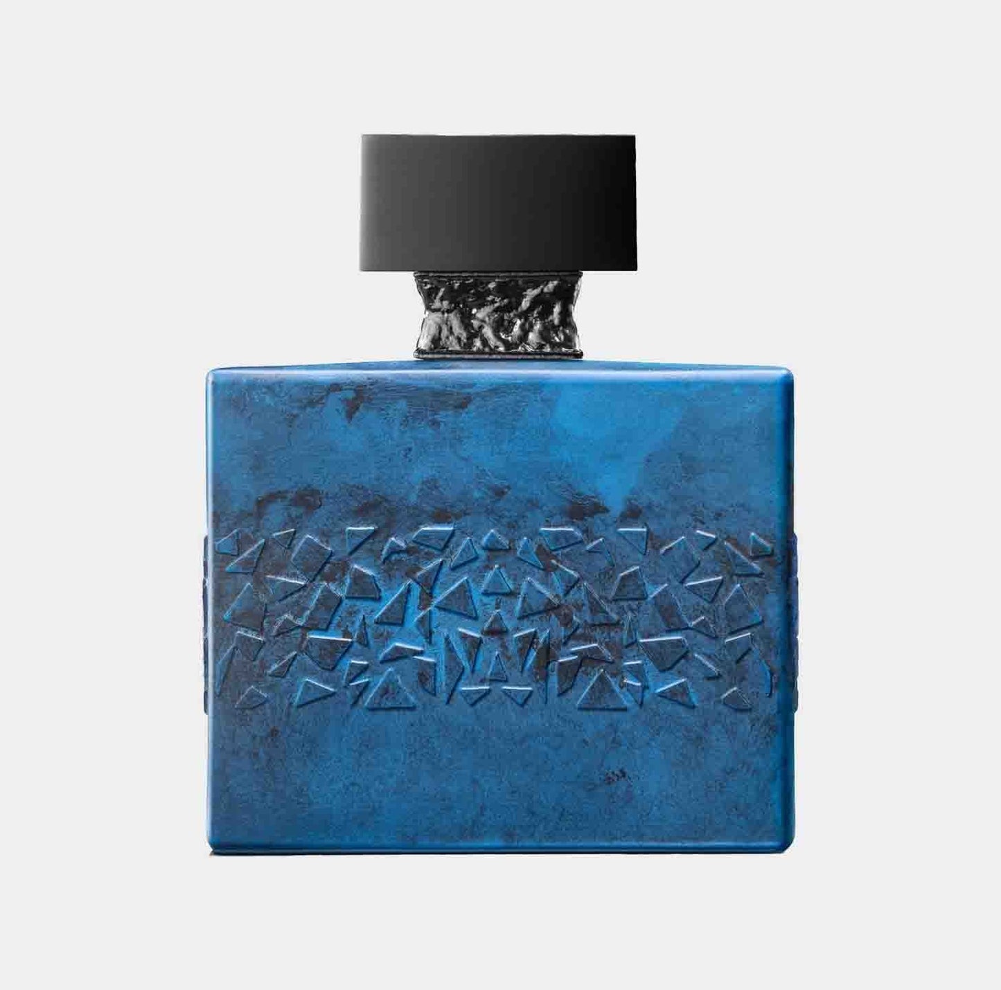 A full bottle of M. Micallef DesirToxic perfume featuring a textured blue square design and a black cap, exuding a modern and luxurious aesthetic.