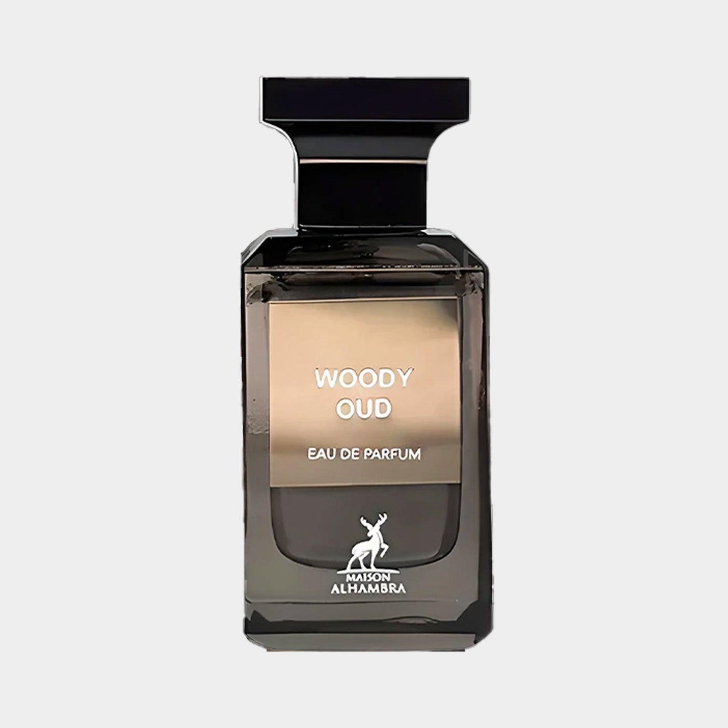 A sleek, dark glass bottle of Maison Alhambra Woody Oud Sample, featuring a minimalist design with a prominent label that reads Woody Oud Eau de Parfum.