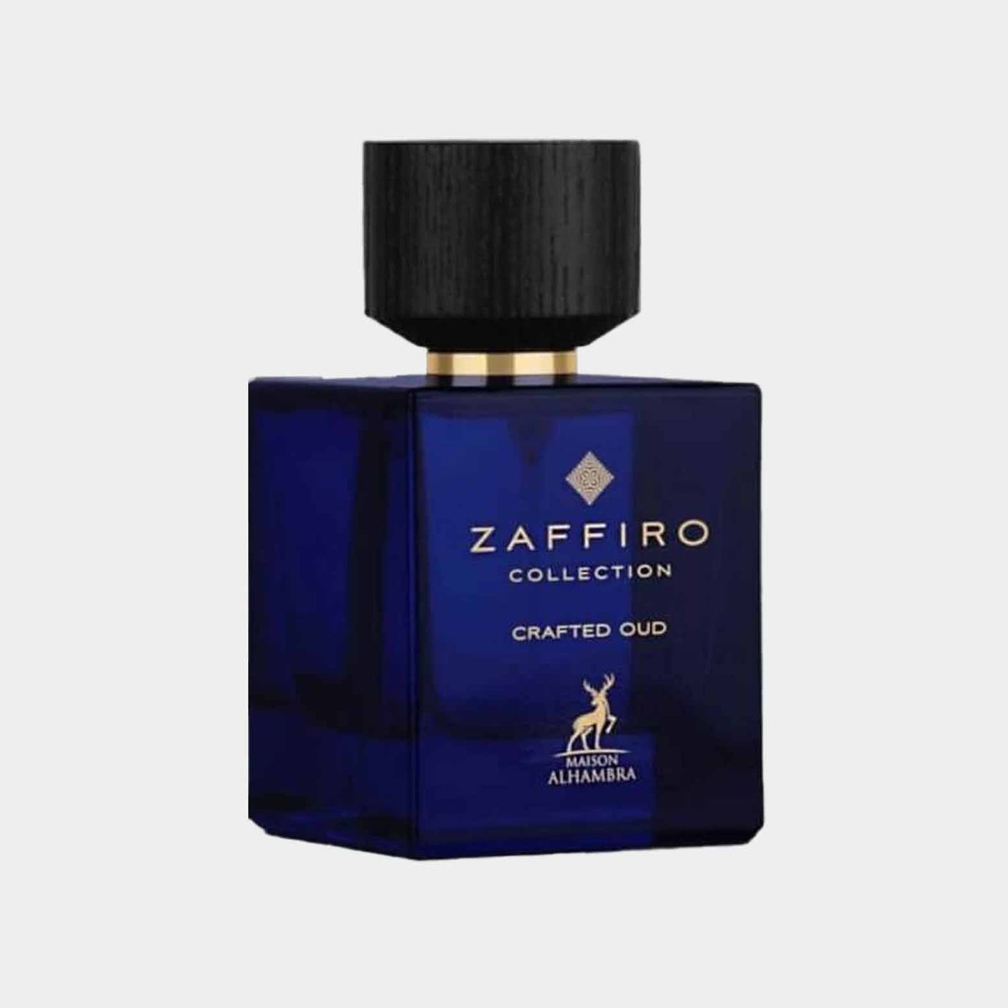 A blue glass perfume bottle from the Maison Alhambra Zaffiro Collection, labeled 'Crafted Oud,' featuring a wooden cap and gold accents.