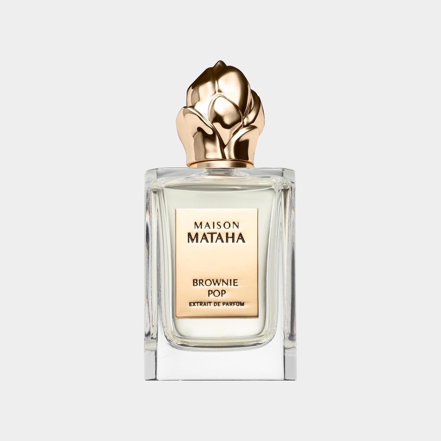 A full bottle of Maison Mataha Brownie Pop perfume, featuring a luxurious design with a golden floral cap and a clear glass body showcasing the fragrance inside.