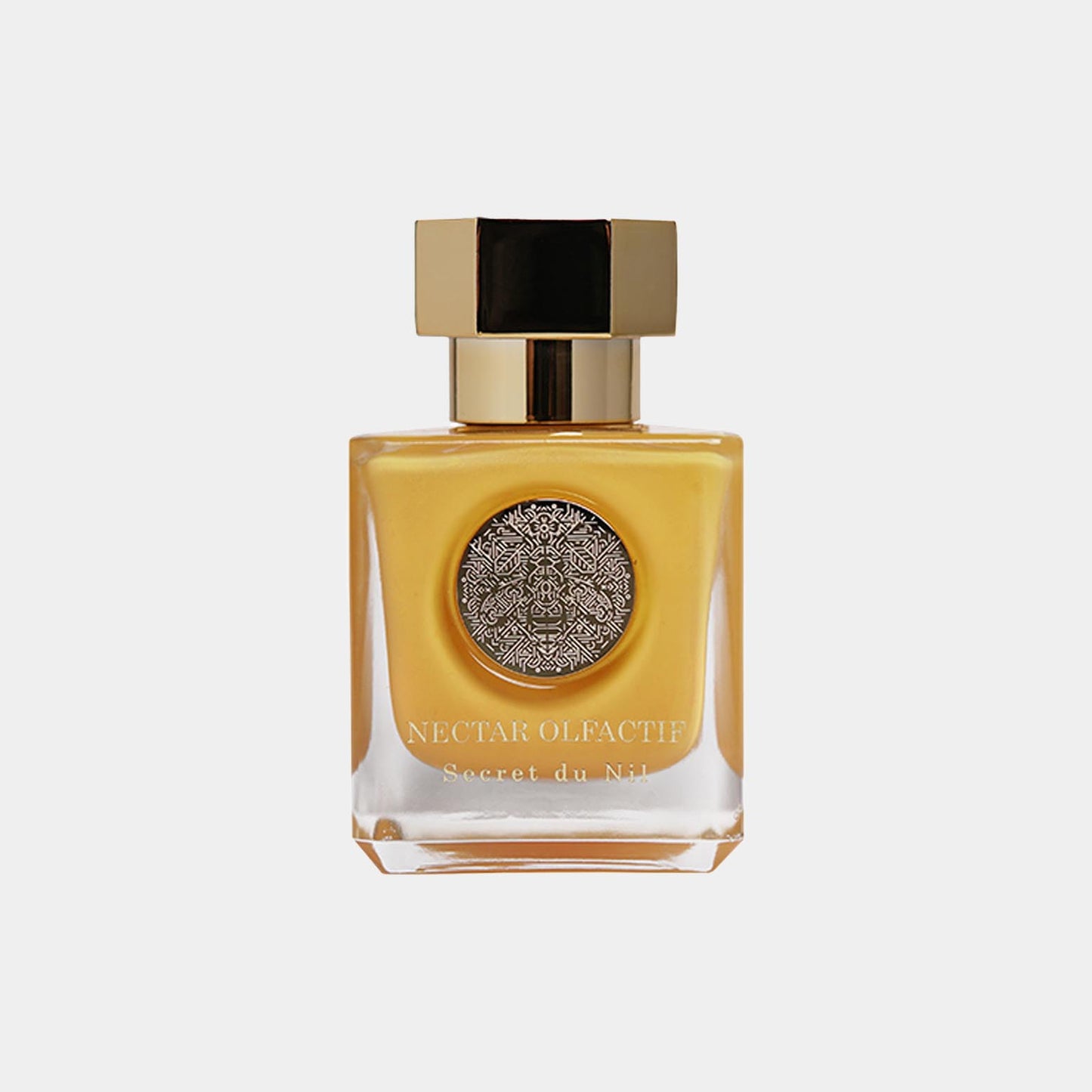 A sleek bottle of Nectar Olfactif Secret du Nil Sample, featuring a gold cap and an intricate silver emblem on the front, encased in a stylish square design. The perfume exudes elegance and luxury.