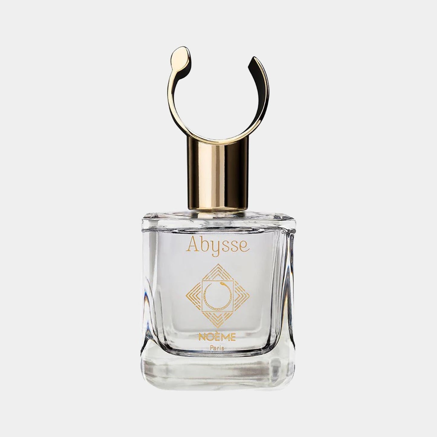 A clear glass bottle of Noème Paris Abysse Sample perfume, featuring a sleek design with a gold cap and a circular ornament on top. The label displays the name Abysse and the brand Noème Paris.