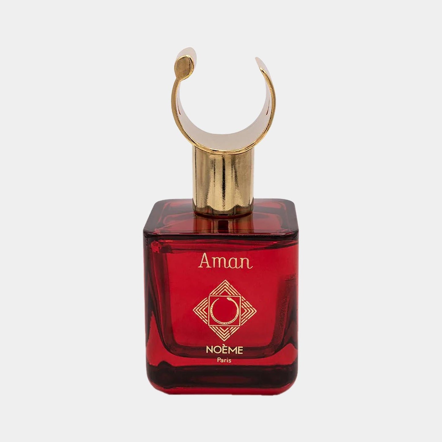 A luxurious red glass bottle of Noème Paris Aman Sample perfume, featuring an elegant gold cap with a unique crescent shape and intricate logo design on the front.