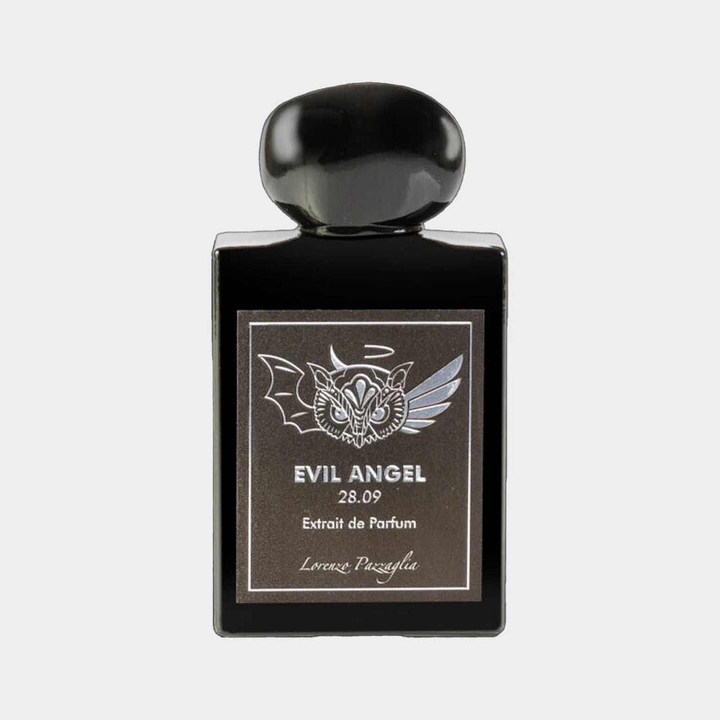 A sleek black bottle of Lorenzo Pazzaglia Evil Angel Extrait de Parfum, featuring a decorative label with bat and wing designs, evokes a mysterious and captivating essence. The minimalist design and bold typography highlight the fragrance's unique character.