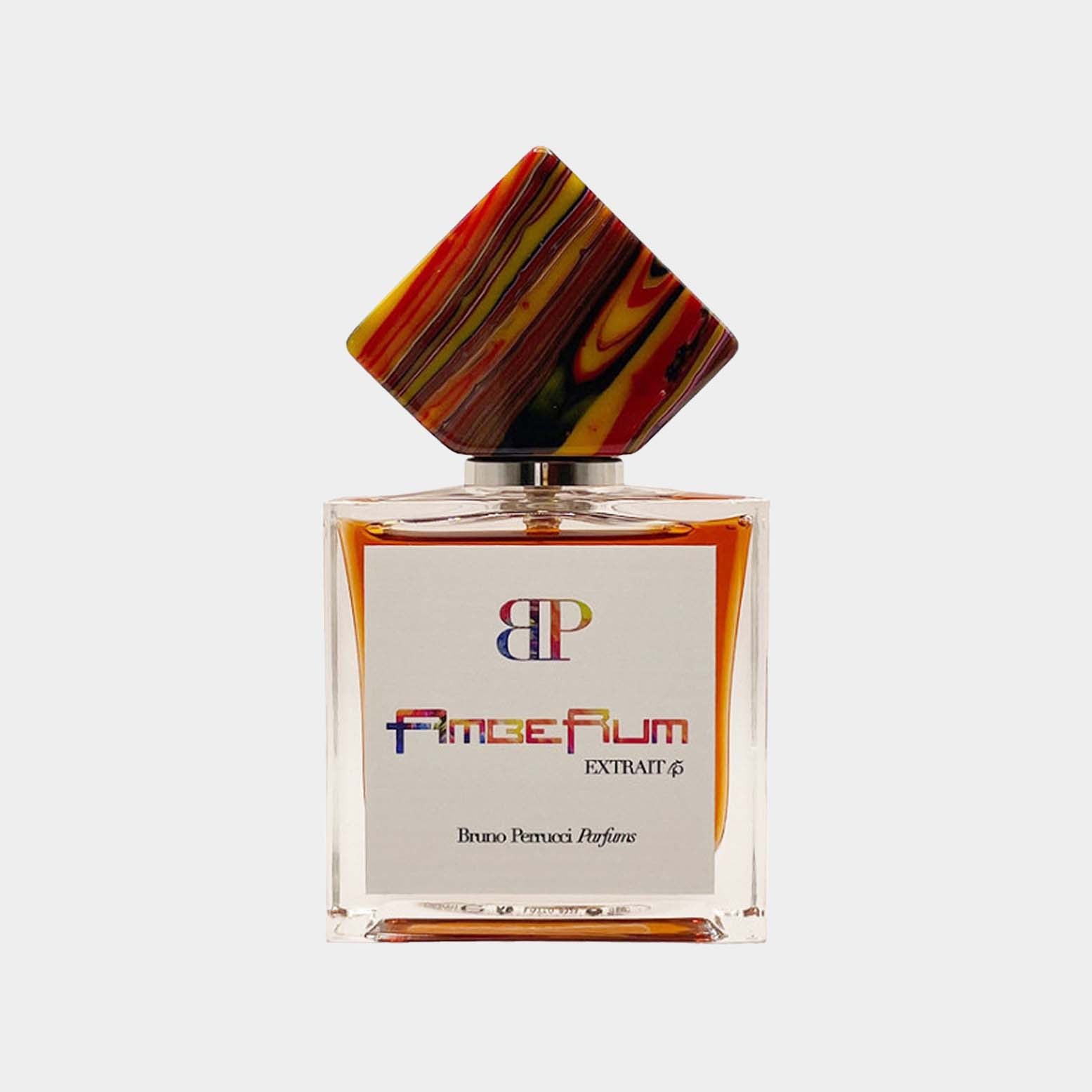 A stylish glass perfume bottle featuring a colorful, artistic cap, labeled Bruno Perrucci AmbeRum Sample with elegant typography, showcasing the luxury fragrance within.