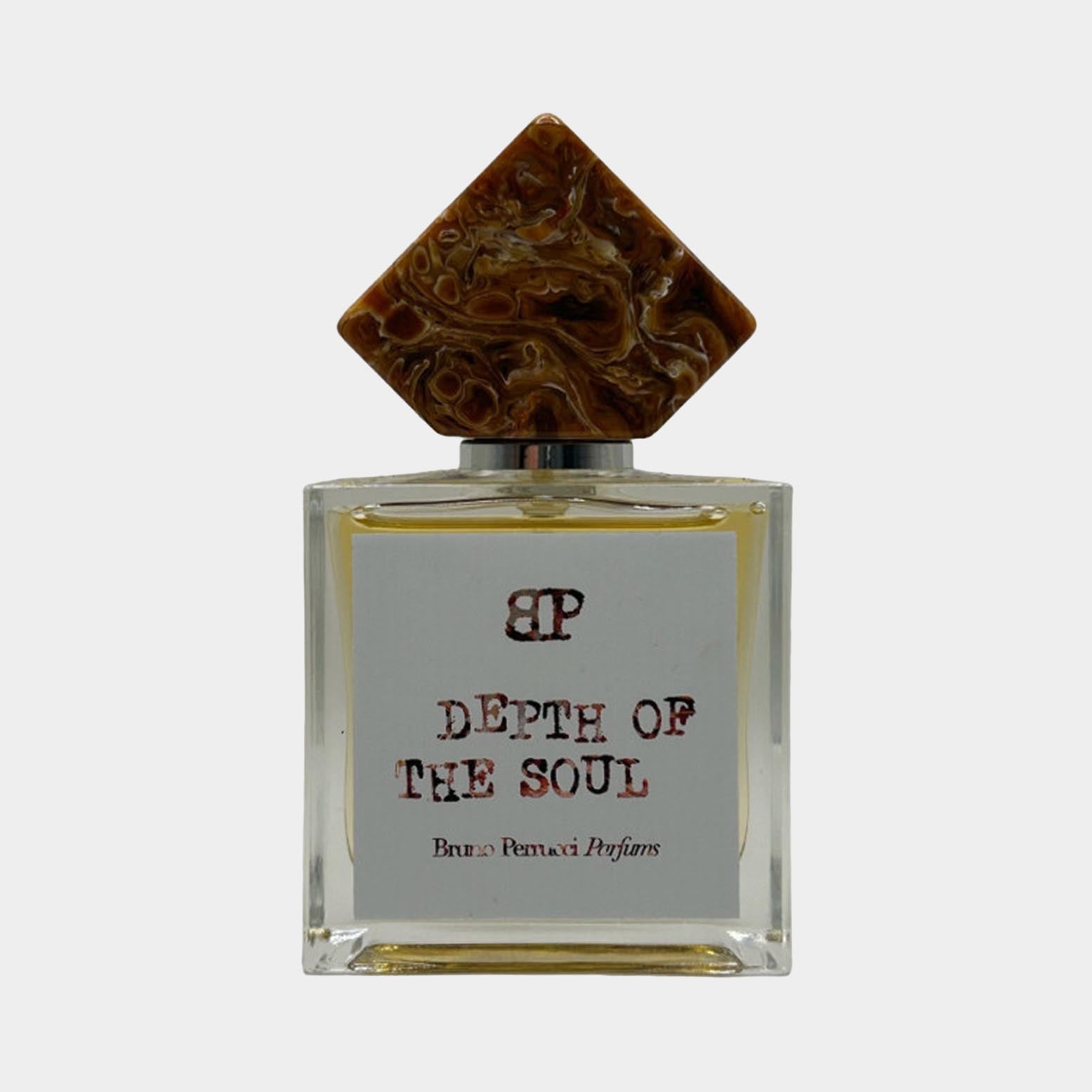 A full bottle of Bruno Perrucci Depth of Soul perfume, featuring a clear rectangular glass design with a decorative, sculptural cap. The label displays the brand name and fragrance title in elegant typography.