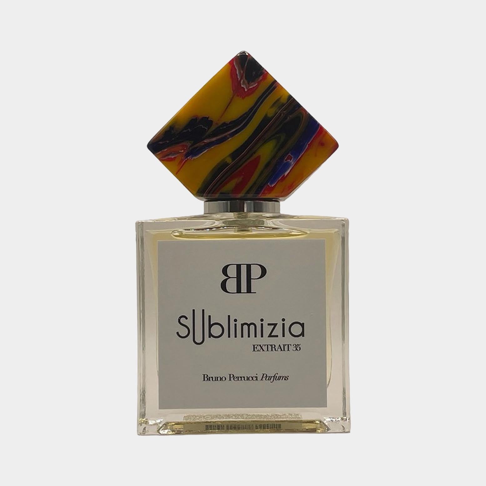 A stylish perfume bottle of Bruno Perrucci Sublimizia Sample features a unique multi-colored geometric cap and a sleek transparent design, highlighting the luxurious fragrance within.