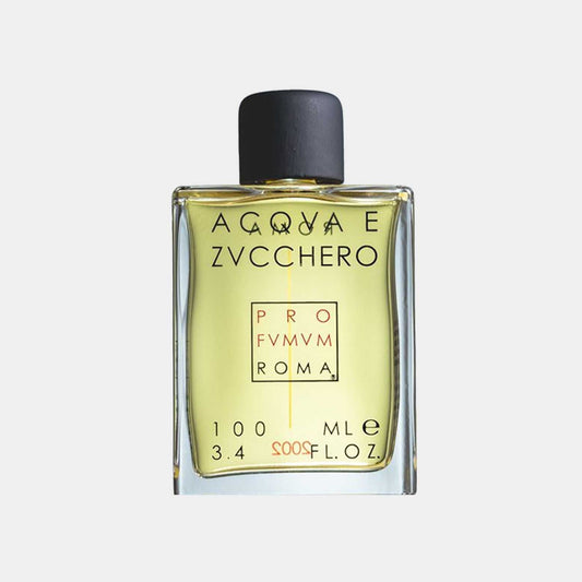 A small glass bottle of Profumum Roma Acqua e Zucchero fragrance sample, featuring a yellow liquid and a black cap, labeled with elegant lettering.