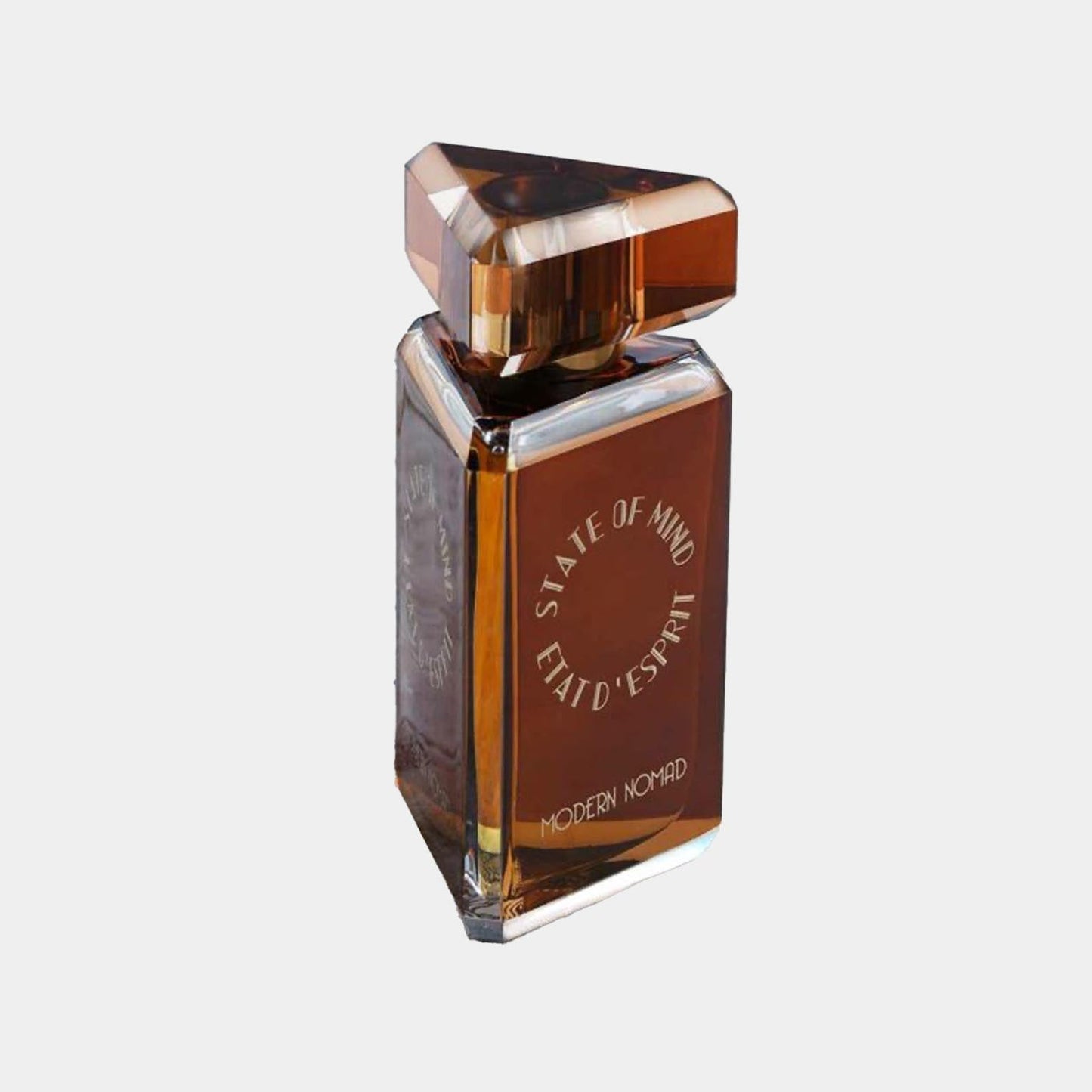 A sleek, angular perfume bottle labeled State of Mind Modern Nomad Sample, featuring a rich amber liquid and an eye-catching geometric cap.