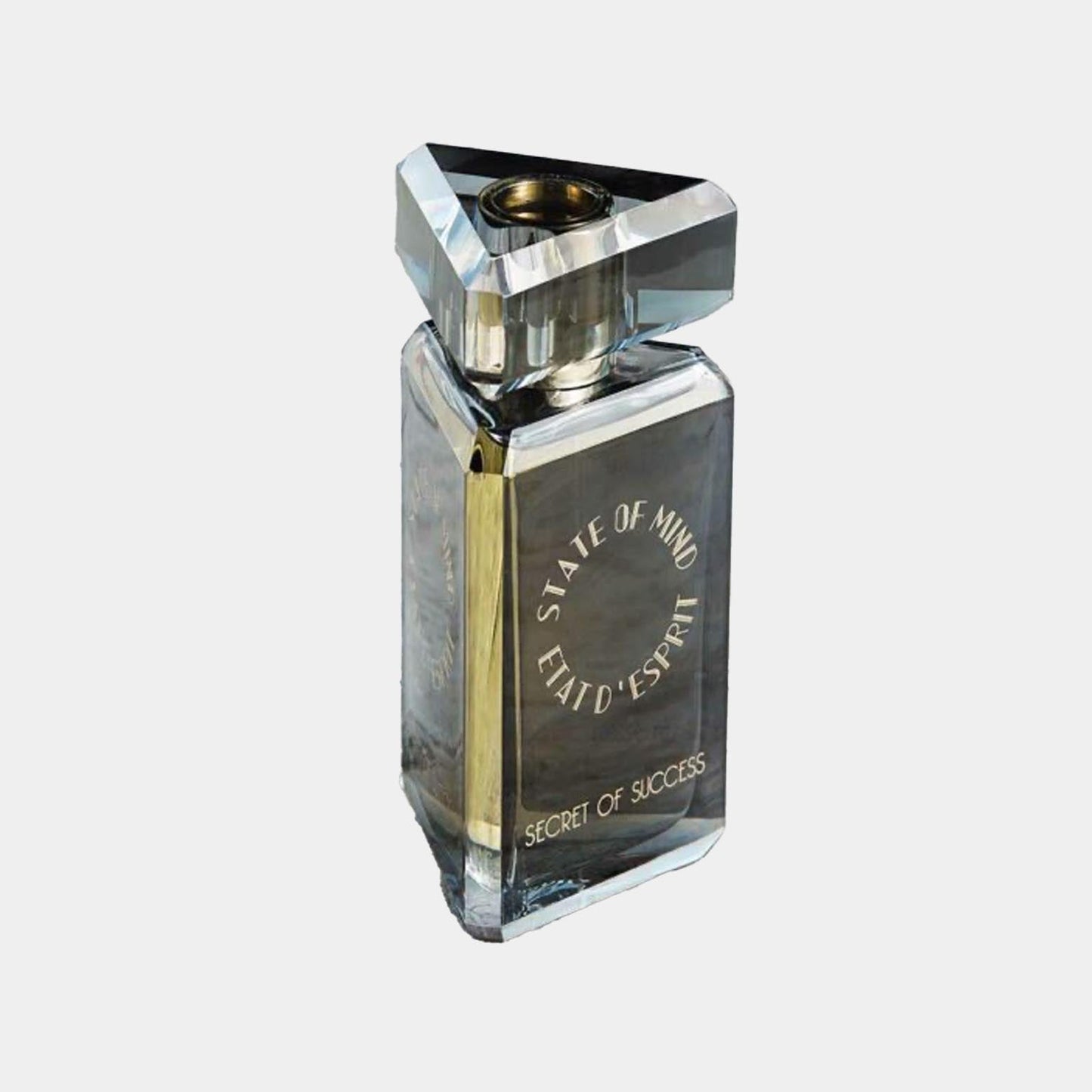 A sleek, triangular glass perfume bottle labeled 'State of Mind Secret of Success'. The bottle features a modern design with gold accents and a minimalist aesthetic.