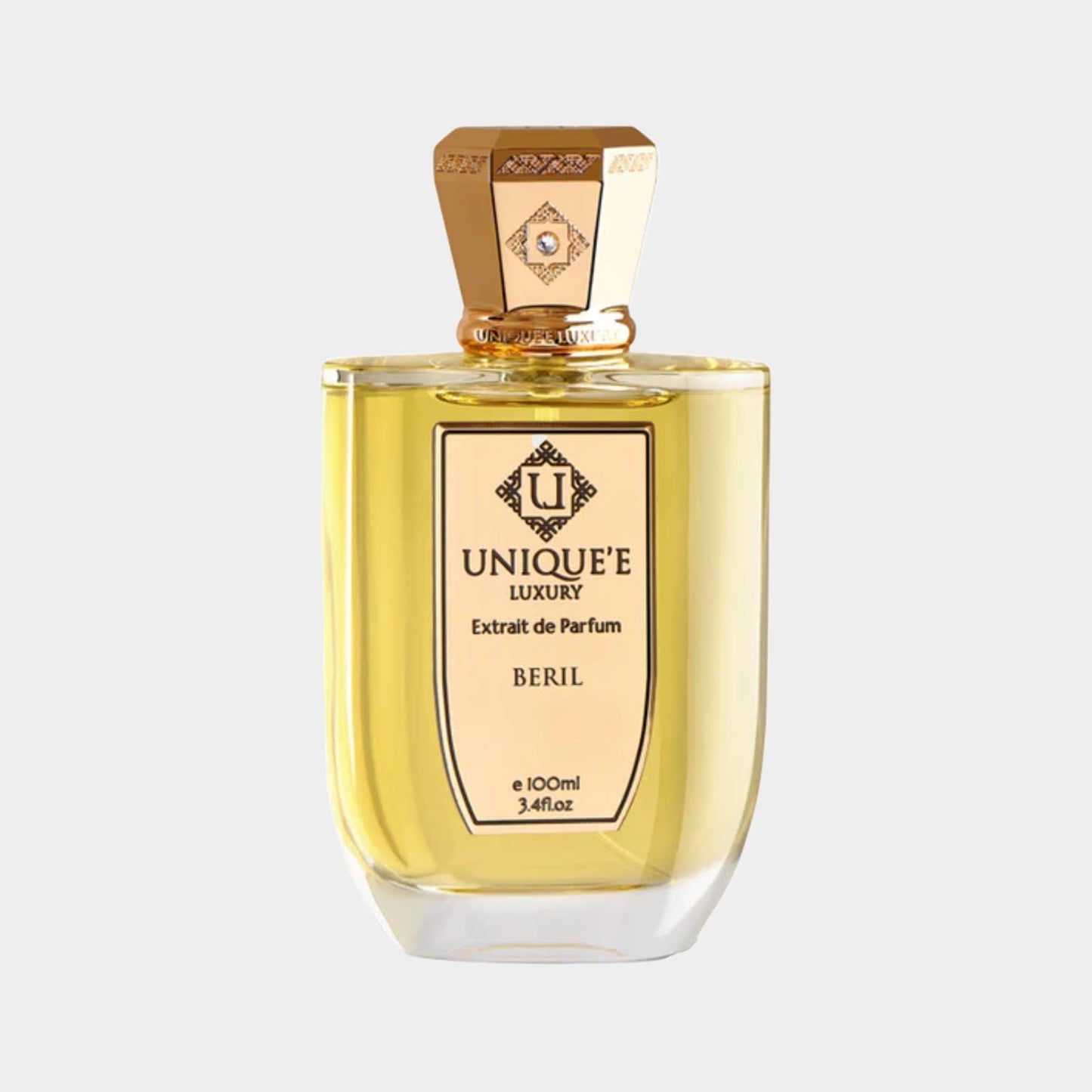 A bottle of Unique'e Luxury Beril Sample, featuring a golden liquid in an elegant glass container with a decorative gold cap, labeled as Extrait de Parfum.