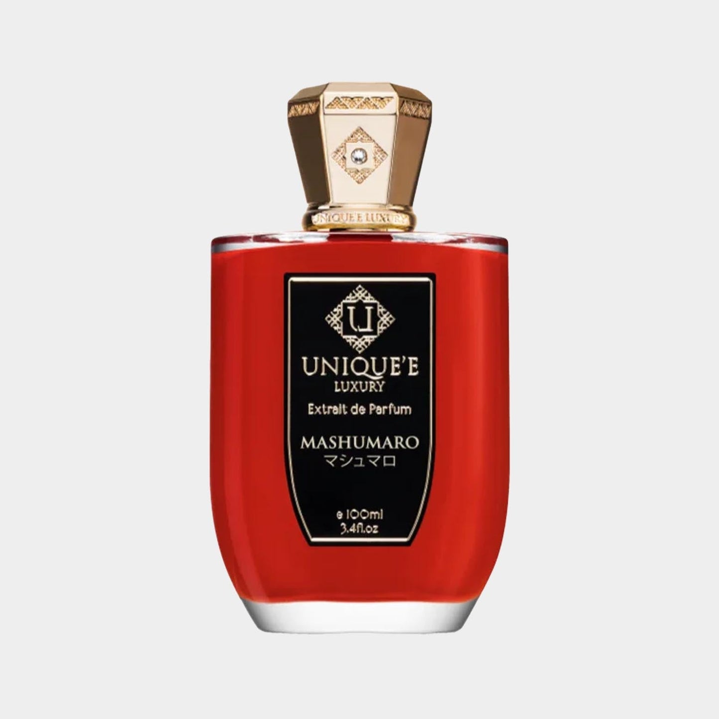 A sleek bottle of Unique’e Luxury Mashumaro Sample, featuring a distinctive red liquid and an ornate gold cap. The label showcases elegant branding, indicating it's an extrait de parfum in a 100ml size.