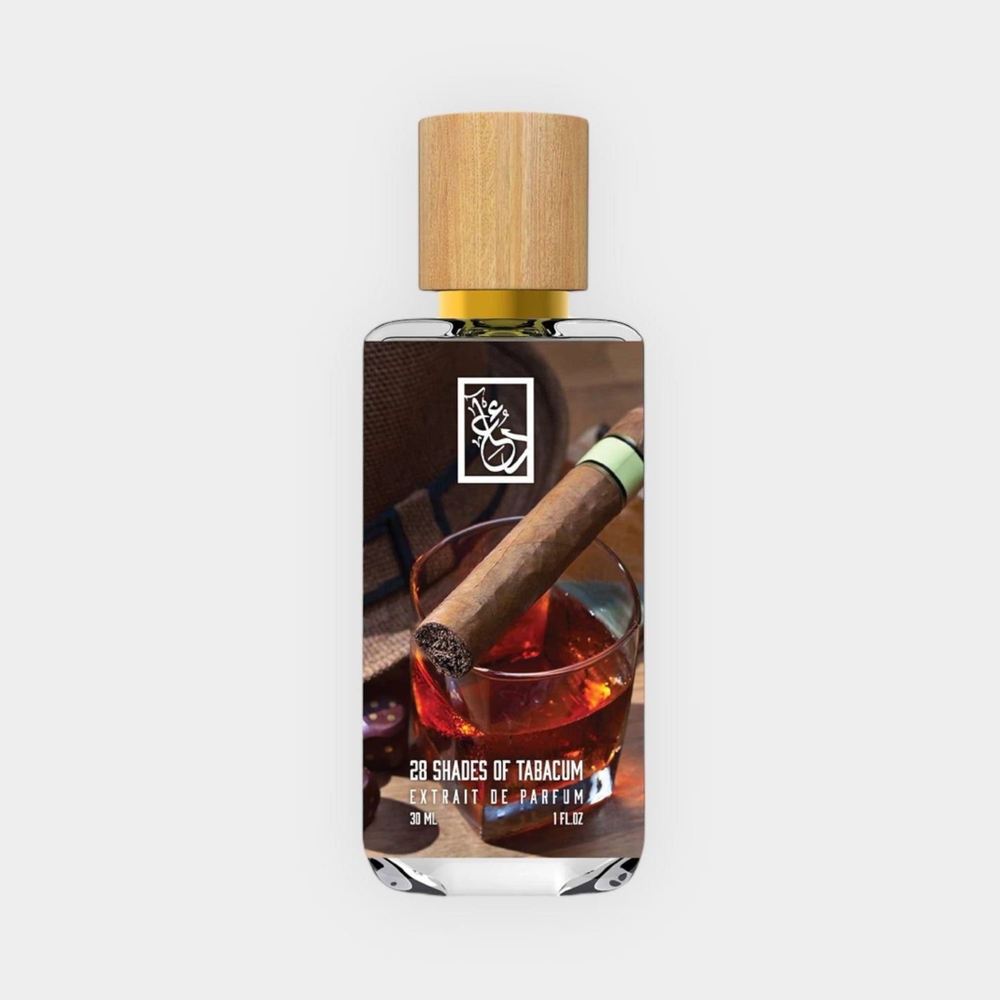 A sleek bottle of Dua 28 Shades of Tabacum Sample, featuring a wooden cap and an image of a cigar resting on a glass filled with a rich beverage. The scent is presented as an extrait de parfum, enhancing its luxurious appeal.