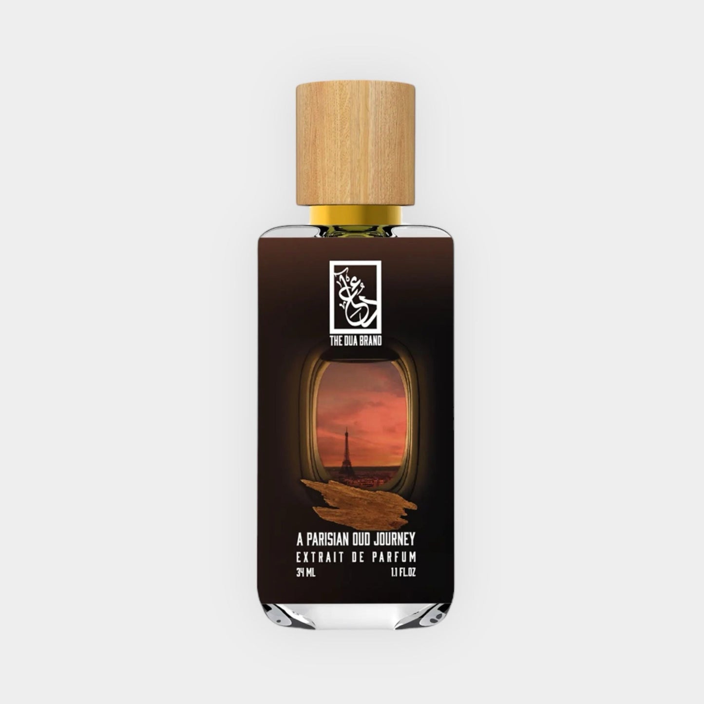 A sleek bottle of Dua A Parisian Oud Journey Sample with a wooden cap, featuring an elegant design that highlights a sunset view of Paris. The label indicates it's an extrait de parfum, showcasing a luxurious fragrance experience.