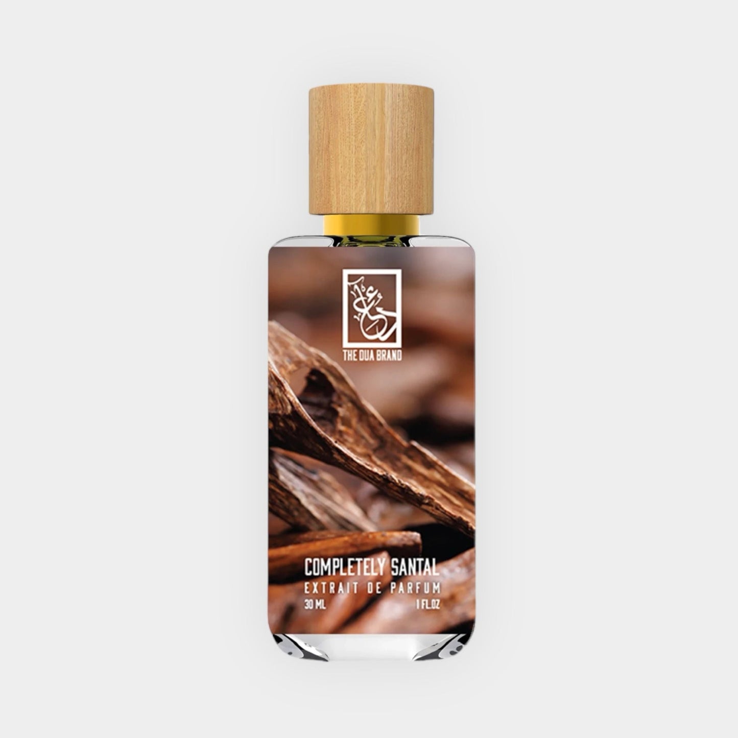 A sleek glass bottle of Dua Completely Santal Sample, featuring a wooden cap and a label showcasing its name and brand, set against a soft gray background. The bottle contains 30 mL of an exquisite sandalwood fragrance.