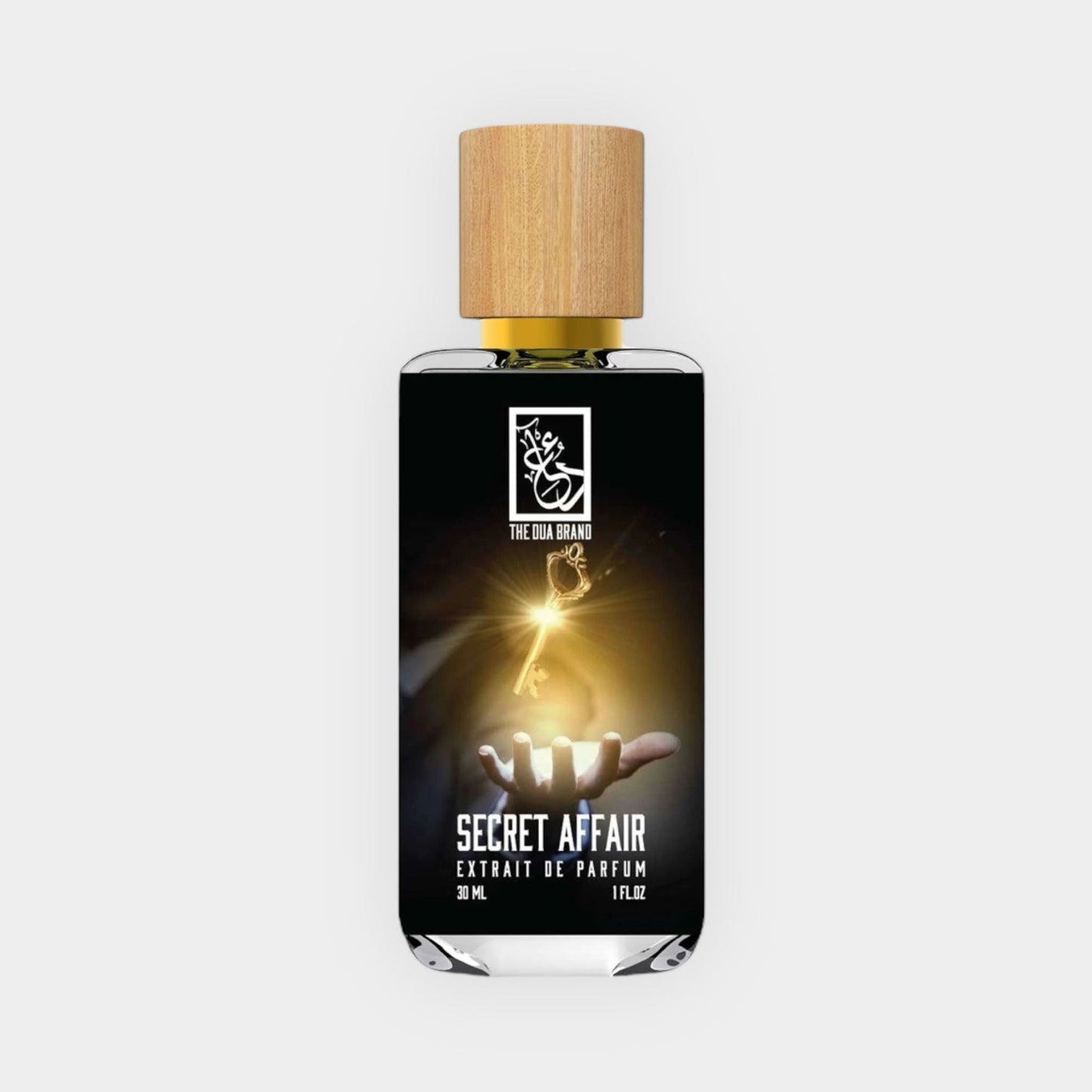 Dua Secret Affair Sample is a 30 ml extrait de parfum showcased in an elegant glass bottle with a wooden cap, featuring a mystical design displaying a hand and a glowing light. The label highlights the fragrance name Secret Affair in bold letters.
