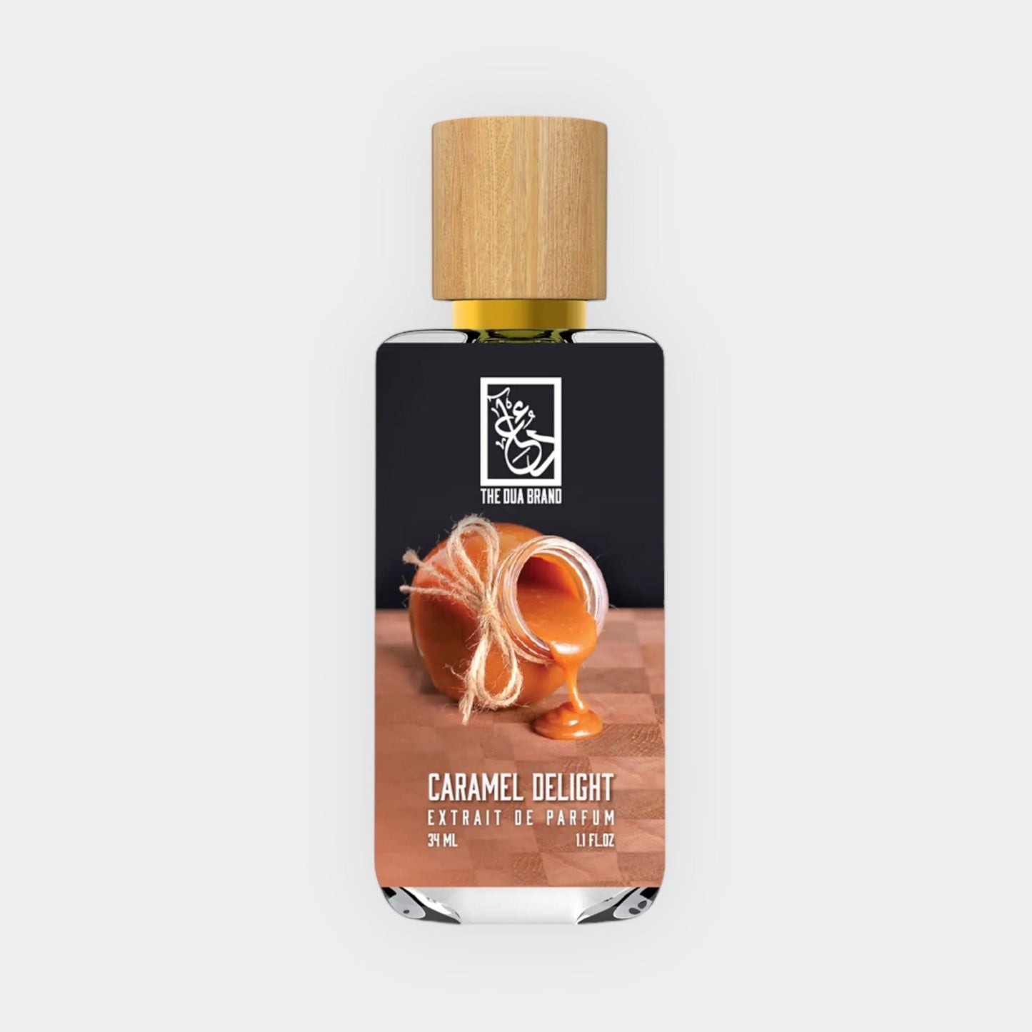 Dua Caramel Delight Sample - a 3ml amber fragrance bottle featuring a wooden cap and a label showcasing a caramel dessert, elegantly presented on a textured surface.