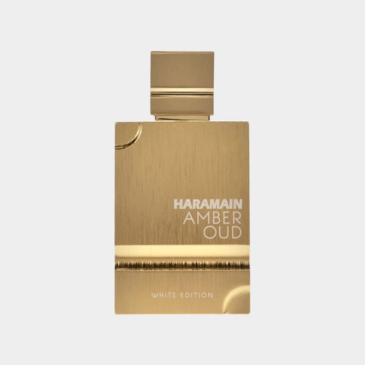 Al Haramain Amber Oud White Edition Cologne Sample features an elegant gold bottle with a sleek design. The label prominently displays the brand name and product details.