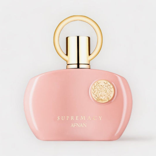 Afnan Perfumes Supremacy Pour Femme Pink Sample features an elegant blush pink bottle with a gold cap and a decorative emblem, exuding sophistication and femininity.