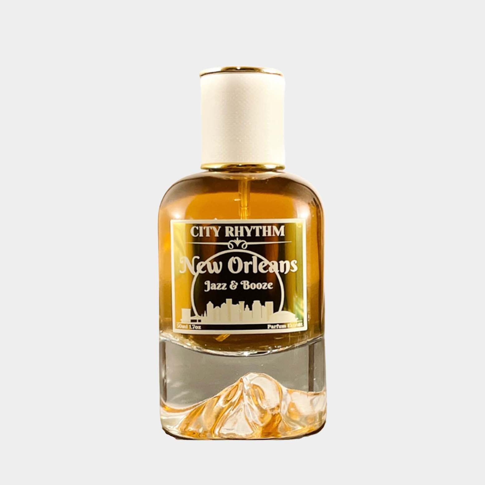 A sleek glass bottle of City Rhythm New Orleans Jazz & Booze sample fragrance, featuring a gold and white label with a skyline design. The warm, amber liquid inside is highlighted by the elegant shape of the bottle.