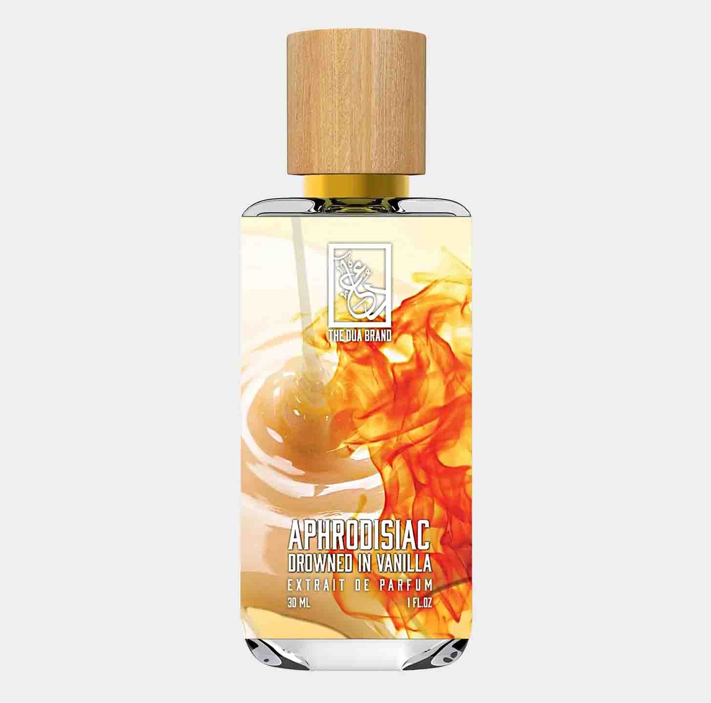 A sleek glass bottle of Dua Aphrodisiac Drowned in Vanilla perfume, showcasing a warm, amber liquid and topped with a natural wood cap. The label features elegant typography against a backdrop of swirls resembling vanilla and amber.