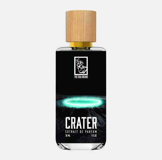Bottle of 'Dua Crater Sample' perfume, featuring a sleek design with a black label and wooden cap, set against a minimalist background. The label displays the name CRATER prominently, suggesting a unique and captivating fragrance experience.