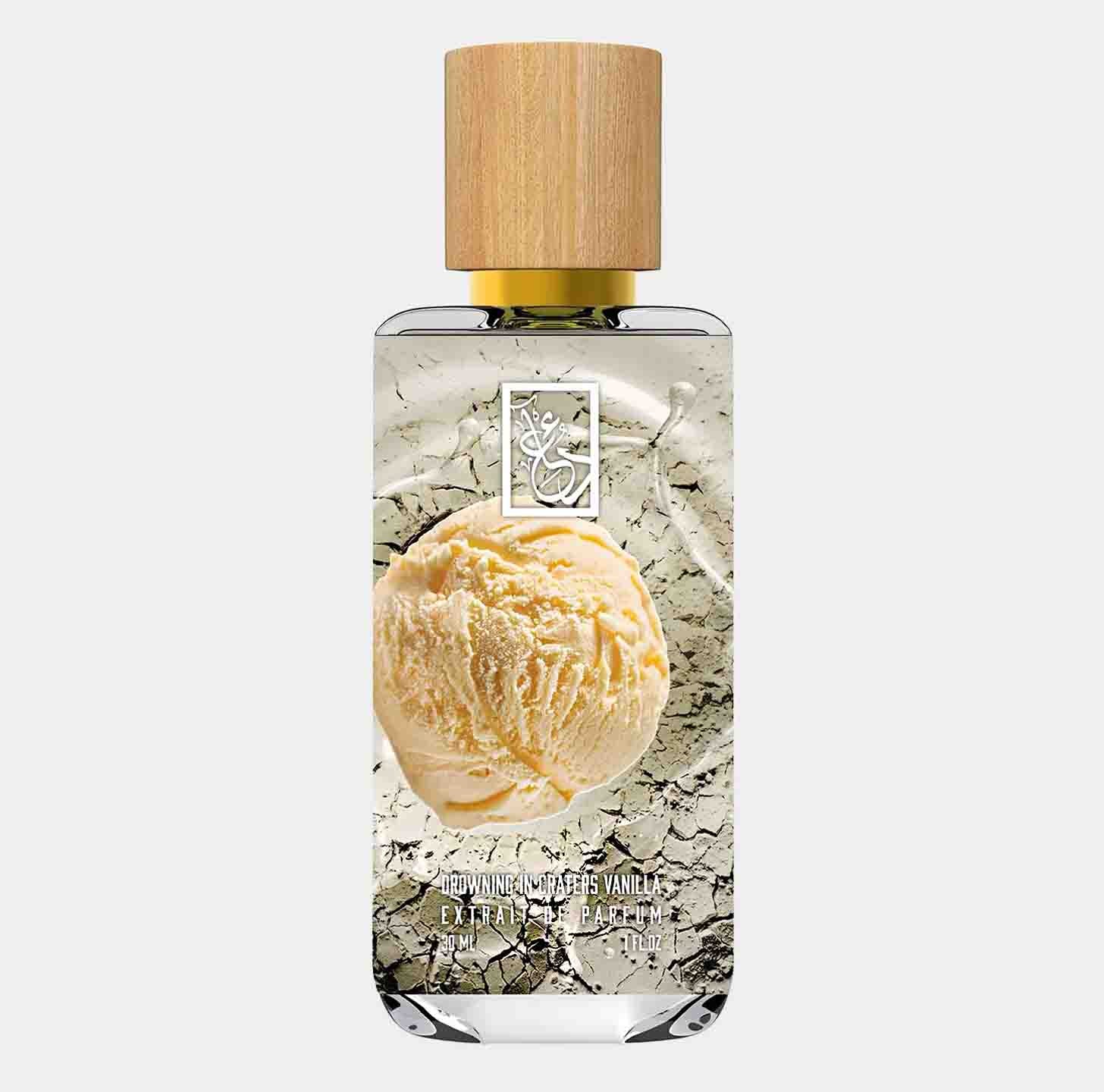 A bottle of Dua Drowning in Craters Vanilla Sample, featuring a wooden cap and an image of creamy vanilla ice cream set against a cracked earth background. The fragrance is presented in a clear glass bottle, showcasing its elegant design.