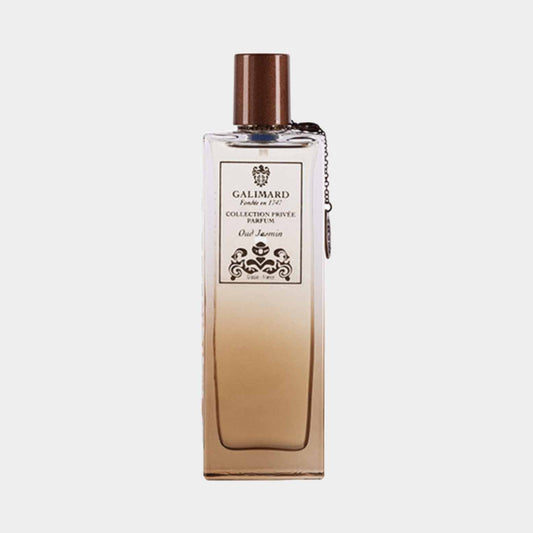 A sample bottle of Galimard Oud Jasmin from the Collection Privée, featuring an elegant design with a brown cap and a decorative chain. The bottle showcases a gradient from clear to amber.