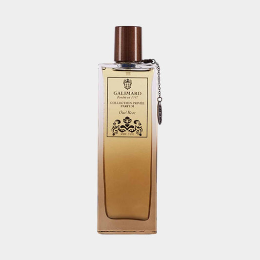 A sleek, elegant bottle of Galimard Oud Rose Collection Privée perfume, featuring a dark brown cap and a decorative charm. The label highlights its luxurious scent, blending oud and rose for a sophisticated fragrance experience.