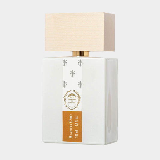 A full bottle of Giardini di Toscana Bianco Oro, featuring a sleek white body and a light wooden cap, measuring 100 ml (3.4 fl oz). The elegant design showcases a golden label, emphasizing its luxurious appeal.
