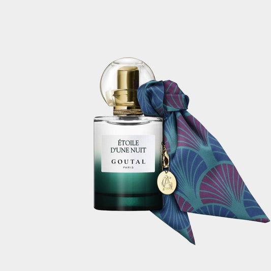 A sleek bottle of Goutal Étoile d'Une Nuit perfume, featuring a gradient green design and topped with a decorative ribbon and gold accents. The elegant shape and luxurious details reflect the fragrance’s sophisticated essence.
