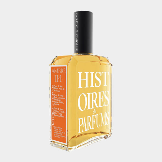 A bottle of Histoires de Parfums Ambre 114 Sample, featuring an amber-colored liquid in a sleek, rectangular glass container with white and orange labeling. The design emphasizes a luxurious and artisanal fragrance experience.
