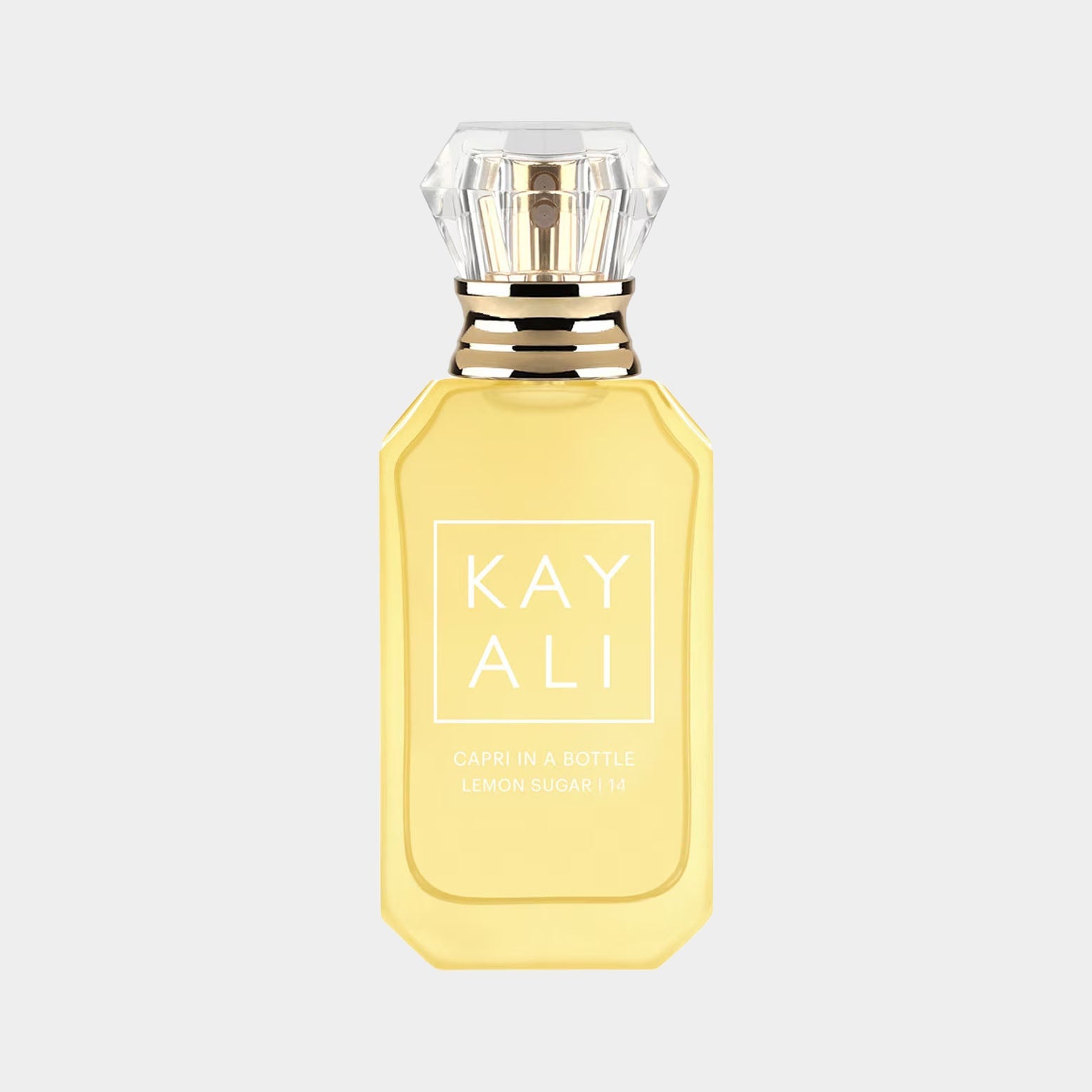 A glass bottle of Kayali Capri In A Bottle Lemon Sugar 14, featuring a bright yellow liquid and a diamond-shaped cap. The bottle is elegantly designed with a minimalist label displaying the brand name and fragrance title.