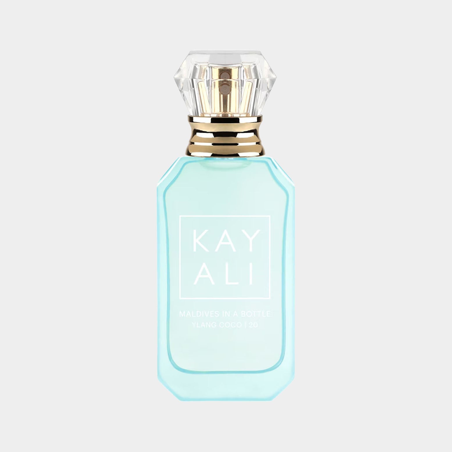 A turquoise bottle of Kayali Maldives In A Bottle Ylang Coco 20, featuring a diamond-shaped cap and elegant branding. The fragrance is designed to evoke a tropical paradise experience.